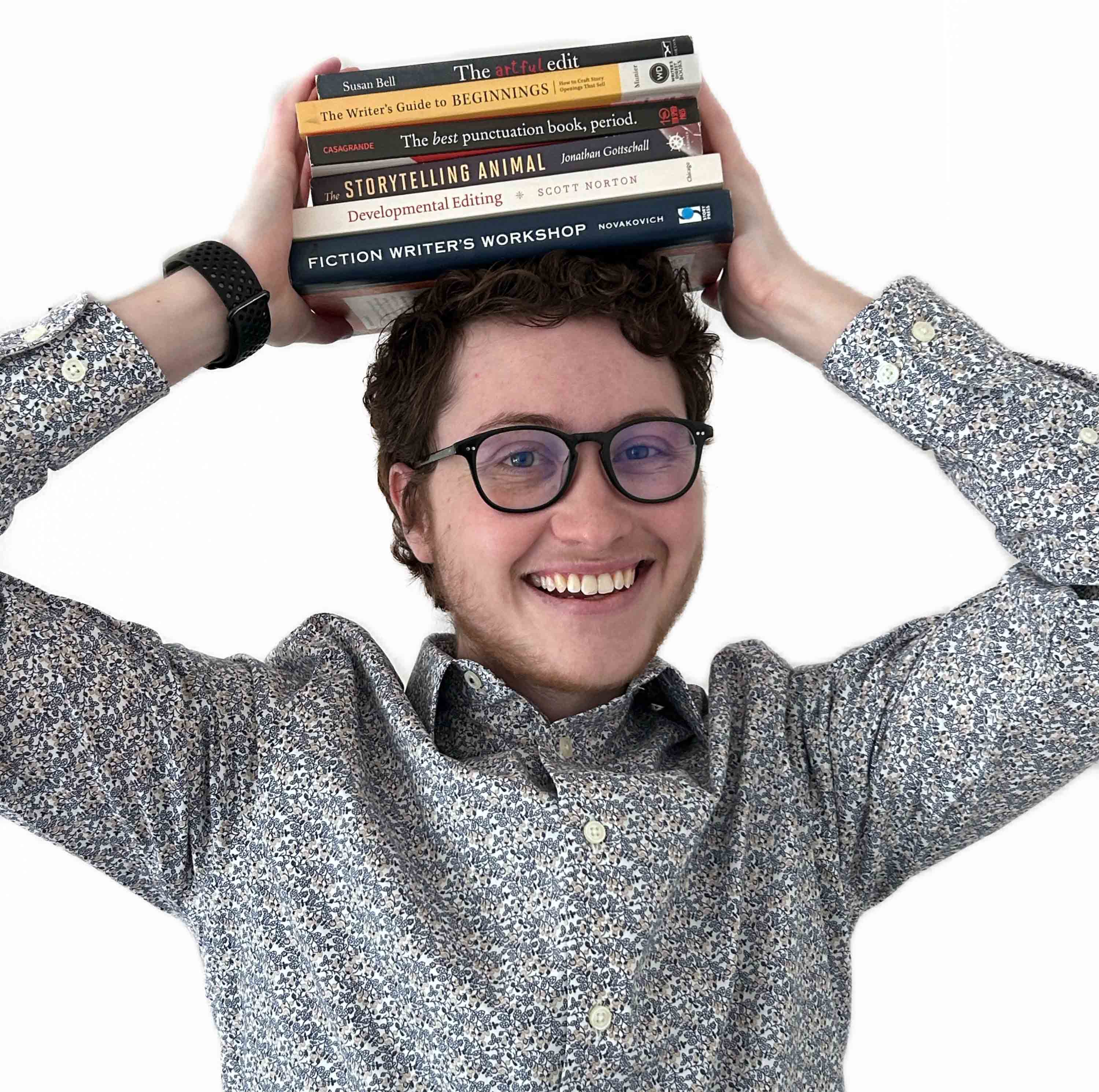 Mouse Larisheva, an adult white man with curly hair, holds a stack of books on his head.